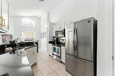 a kitchen with a stainless steel refrigerator and appliances at Casa térrea c/ piscina e 2 suítes, sem carpete in Kissimmee