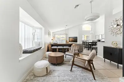 a living room with white walls and a dining room at Casa térrea c/ piscina e 2 suítes, sem carpete in Kissimmee