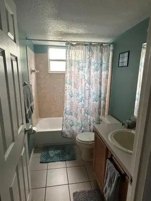a bathroom with a tub and a toilet and a sink at Bright Condo near Disney and Universal in Kissimmee