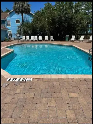 a swimming pool with blue water in a yard at Bright Condo near Disney and Universal in Kissimmee
