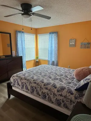 a bedroom with a bed and a ceiling fan at Bright Condo near Disney and Universal in Kissimmee