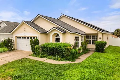 a house with a green yard in front of it at Residentas Indian Creek in Kissimmee