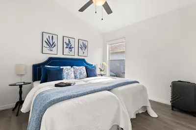 a bedroom with a blue and white bed and a ceiling fan at Residentas Indian Creek in Kissimmee