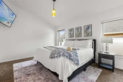 a white bedroom with a bed and a window at Residentas Indian Creek in Kissimmee