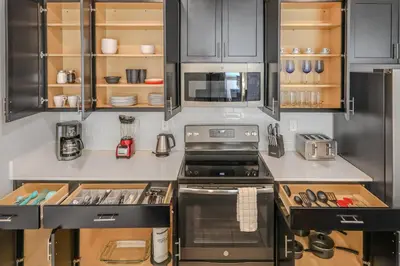 a kitchen with stainless steel appliances and black cabinets at 4BR Pool Home Ideal for Families in Kissimmee