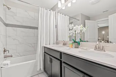 a bathroom with a sink and a shower and a tub at 4BR Pool Home Ideal for Families in Kissimmee