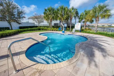 a swimming pool with palm trees in a resort at 4BR Pool Home Ideal for Families in Kissimmee