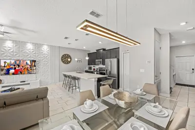a living room and kitchen with a couch and a table at 4BR Pool Home Ideal for Families in Kissimmee