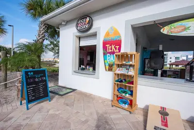 a surf shop with a surfboard on the side of it at 4BR Pool Home Ideal for Families in Kissimmee