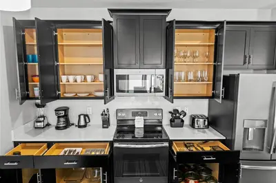 a kitchen with black cabinets and a stove at Private Pool 4BR Home in Orlando in Kissimmee