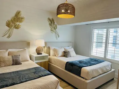 a bedroom with two beds and a lamp and a window at Condo near Epic & Universal,free parking & Netflix in Orlando