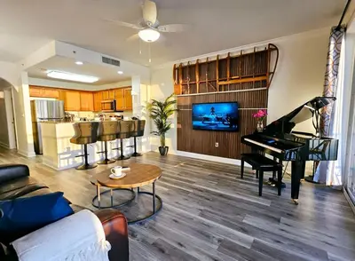 a living room with a piano and a kitchen at Stunning waterfront Views 1 mile to Disney 2 bath in Orlando