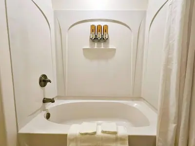 a bathroom with a bath tub with two towels at Stunning waterfront Views 1 mile to Disney 2 bath in Orlando