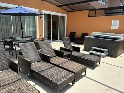a patio with chairs and an umbrella and a table and a piano at Waterfront ParadiseClose 2 DisneyGated Community in Orlando
