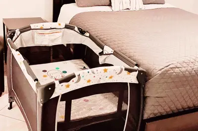 a baby crib sitting next to a bed at Villa Velera in Kissimmee