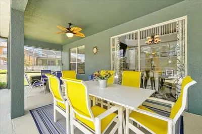 a dining room with a white table and yellow chairs at Emerald Island Resort 6 Bed Pool & Spa villa in Kissimmee