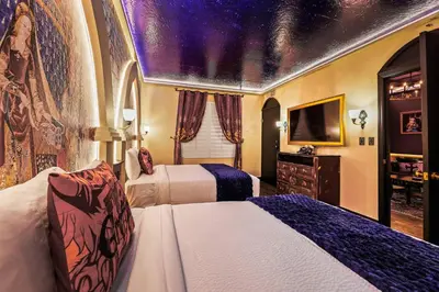 a hotel room with two beds and a television at Harry Potter Stay Near Universal in Orlando