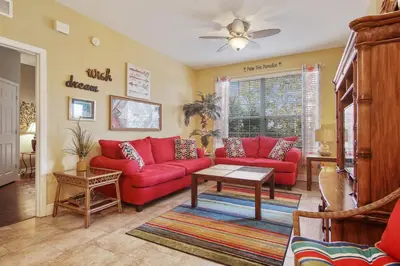 a living room with red couches and a table at Palm Tree Paradise 3 bedroom condo at Windsor Hills close to Disney in Orlando