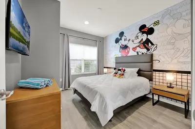 a bedroom with a mickey mouse mural on the wall at Beautiful 3 Bedroom Villa with Private Hot Tub, 10 mins to Disney! in Kissimmee