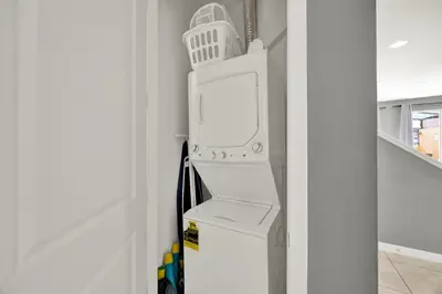 a white refrigerator with a washing machine in a room at Beautiful 3 Bedroom Villa with Private Hot Tub, 10 mins to Disney! in Kissimmee