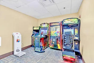 a room with three arcade games and a wii at Modern Condo close to Disney with Arcade and BBQ Grill in Orlando