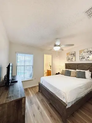 a bedroom with a bed and a flat screen tv at Family Home, Near Disney-Private pool, Spacious 3BR Retreat in Orlando