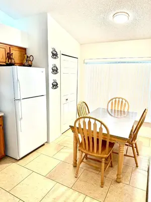 a kitchen with a table and chairs and a refrigerator at Family Home, Near Disney-Private pool, Spacious 3BR Retreat in Orlando