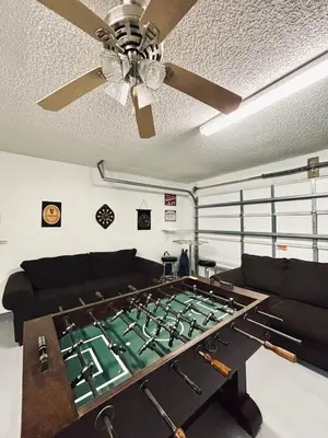 a large pool table in a living room with a ceiling fan at Family Home, Near Disney-Private pool, Spacious 3BR Retreat in Orlando