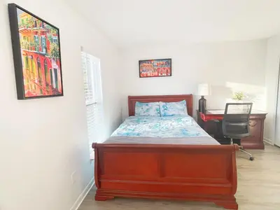 a bedroom with a bed and a desk in a room at Happy Home in Orlando