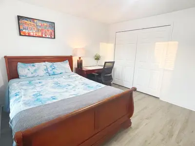 a bedroom with a large bed and a desk with a chair at Happy Home in Orlando