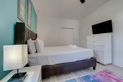 a bedroom with a bed with a dresser and a tv at Bellavida Resort Retreat with Private Pool in Kissimmee