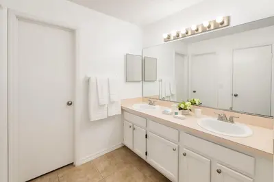 a bathroom with two sinks and a large mirror at Villa Central com Piscina perto da Disney in Kissimmee