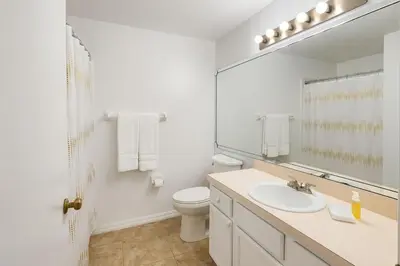 a bathroom with a sink and a toilet and a mirror at Villa Central com Piscina perto da Disney in Kissimmee