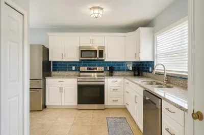 a kitchen with white cabinets and stainless steel appliances at Villa Central com Piscina perto da Disney in Kissimmee