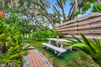 a white picnic table next to a wooden bench at Serenity Spring Lake King Suite in Orlando