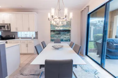 a kitchen and dining room with a white table and chairs at Elsa's Enchanting Escape just 15 minutes to Disney in Kissimmee