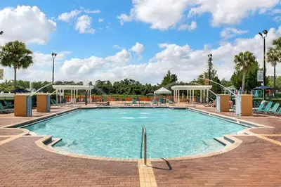 a pool at a resort with chairs and a water park at 3 Bedroom 2 Bathroom Villas At Seven Dwarfs 30-105 in Kissimmee