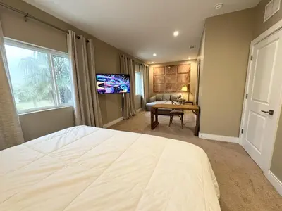a bedroom with a large white bed and a desk at Luxurious 4bed Villa Just 10 Minutes from Disney! Private BBQ in Orlando