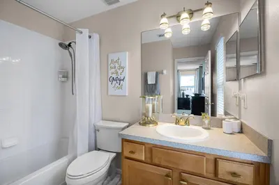 a bathroom with a sink and a toilet and a mirror at Luxurious Family Resort Getaway in Kissimmee