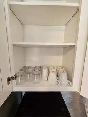 a cupboard filled with dishes and glass jars at Magical Getaway- Cozy Home Minutes from Disney, Restaurants & Outlets! in Kissimmee