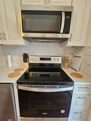a kitchen with a black stove and a microwave at Magical Getaway- Cozy Home Minutes from Disney, Restaurants & Outlets! in Kissimmee