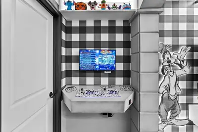 a bathroom with a sink and a tv on a wall at Brand New 05 Bedrooms At Windsor Cay in Orlando