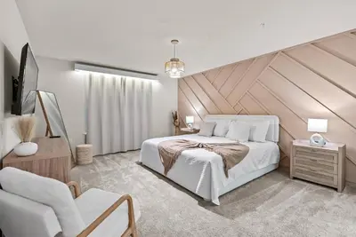 a bedroom with a large white bed and a chair at Brand New 05 Bedrooms At Windsor Cay in Orlando