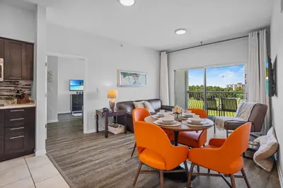 a living room with a table and orange chairs at Spacious Pet Friendly in Orlando