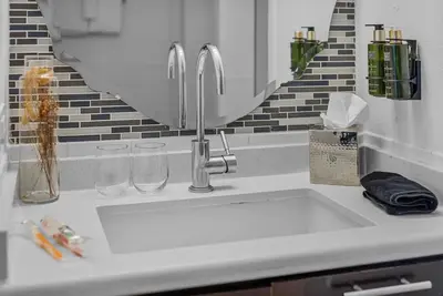 a kitchen counter with a sink and a mirror at Spacious Pet Friendly in Orlando