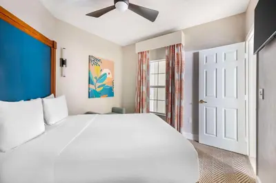 a bedroom with a large white bed and a window at Hilton Vacation Club Cypress Pointe Orlando in Orlando