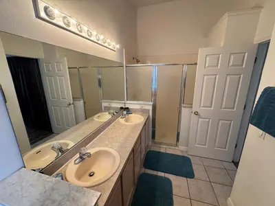 a bathroom with two sinks and a large mirror at Relaxing 3BR/2BA Home - Just 15 Minutes from Disney! in Kissimmee