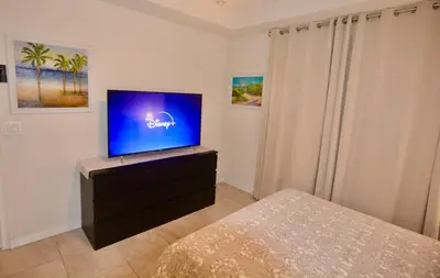 a bedroom with a flat screen tv on a dresser at Storey Lake Resort Condo next to Disney in Kissimmee