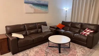 a living room with a brown leather couch and a table at Storey Lake Resort Condo next to Disney in Kissimmee