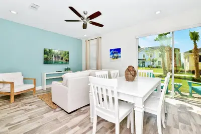 a living room with a white dining room table and chairs at Best Margaritaville Villa Near Disney World in Orlando